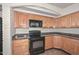 Close up of Kitchen with wooden cabinets, granite countertops, and black appliances at 520 W Gibraltar Ln, Phoenix, AZ 85023