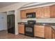 Kitchen featuring wooden cabinets, granite countertops, and black appliances at 520 W Gibraltar Ln, Phoenix, AZ 85023