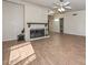 Cozy living room showcasing wood-look tile flooring, a white brick fireplace, and plenty of natural light at 520 W Gibraltar Ln, Phoenix, AZ 85023