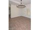 Spacious living room featuring stylish wood-look tile floors and a modern chandelier at 520 W Gibraltar Ln, Phoenix, AZ 85023