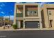 Modern home with a black garage door, minimalist landscaping, and a contemporary balcony design at 6804 E Lyra Dr, Scottsdale, AZ 85257