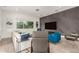 Stylish living room featuring modern furniture, a textured accent wall, and a large window for natural light at 6804 E Lyra Dr, Scottsdale, AZ 85257