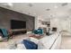 Spacious living room with a textured wall, large TV, and an open layout leading to the kitchen at 6804 E Lyra Dr, Scottsdale, AZ 85257