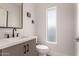 Modern powder room features sleek fixtures, a quartz countertop, under vanity storage, and a vertical window at 6804 E Lyra Dr, Scottsdale, AZ 85257