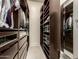 Spacious walk-in closet featuring dark wood shelving units and drawers with carpet floors at 6804 E Lyra Dr, Scottsdale, AZ 85257