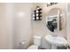 Cozy half-bathroom featuring a pedestal sink, round mirror and decorative toilet paper rack at 7741 W Giles Rd, Phoenix, AZ 85035