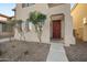 Inviting front entrance with a red door, decorative plants, and well-manicured landscaping at 7741 W Giles Rd, Phoenix, AZ 85035