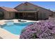 Beautiful backyard pool and patio with desert landscaping and a covered outdoor seating area at 7910 W Adobe Dr, Glendale, AZ 85308