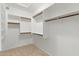 Walk-in closet featuring plenty of built-in shelving and neutral tile floors at 7910 W Adobe Dr, Glendale, AZ 85308