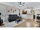 Comfortable living area with a ceiling fan, black leather sofa, and a pass-through to the kitchen at 8005 S 69Th Ln, Laveen, AZ 85339