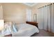 Cozy bedroom featuring a queen bed, lots of pillows, and an ensuite bathroom at 8432 S 21St Pl, Phoenix, AZ 85042