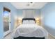 Bright bedroom featuring a queen bed, balcony access, and soft blue walls at 8432 S 21St Pl, Phoenix, AZ 85042