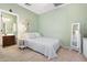 Inviting bedroom with soft green walls, a queen bed, and a glimpse into the en-suite bathroom at 8432 S 21St Pl, Phoenix, AZ 85042