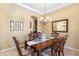 Formal dining room featuring chandelier, wall art, and an arched doorway at 8432 S 21St Pl, Phoenix, AZ 85042