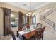 Formal dining room with a chandelier, arched doorway, and wrought iron stair case at 8432 S 21St Pl, Phoenix, AZ 85042