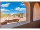 Arched window view showcasing neighborhood rooftops and the distant desert landscape under a bright blue sky at 8432 S 21St Pl, Phoenix, AZ 85042