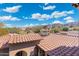 Tile rooftops complement the desert landscape, captured under a vibrant blue sky with fluffy clouds at 8432 S 21St Pl, Phoenix, AZ 85042