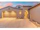 Charming home featuring a three-car garage, an arched entryway, and elegant stone accents at 8432 S 21St Pl, Phoenix, AZ 85042