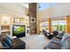 Bright living room featuring a stone fireplace, built-in shelving, and comfortable sofas with a patio view at 8432 S 21St Pl, Phoenix, AZ 85042