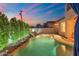 Backyard twilight view of the private pool with a rock waterfall feature and perimeter lighting at 8432 S 21St Pl, Phoenix, AZ 85042