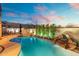 Backyard pool with rock waterfall, surrounded by lush greenery and an outdoor dining area at 8432 S 21St Pl, Phoenix, AZ 85042