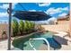 Backyard pool featuring clear water, lush landscaping, and an umbrella for shade at 8432 S 21St Pl, Phoenix, AZ 85042