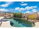 Private backyard pool with rock features surrounded by desert landscaping under a blue sky at 8432 S 21St Pl, Phoenix, AZ 85042