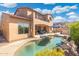 Backyard view of a private pool with rock features, desert landscaping, and a covered patio at 8432 S 21St Pl, Phoenix, AZ 85042