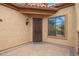 The front entrance has a steel door with a window nearby on a brick patio at 9041 E Ivyglen Cir, Mesa, AZ 85207