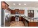 Bright kitchen features dark wood cabinets, stainless steel appliances, and a granite countertop island at 9041 E Ivyglen Cir, Mesa, AZ 85207