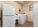 A bright laundry room features a white washer, dryer, laundry sink, and refrigerator at 9041 E Ivyglen Cir, Mesa, AZ 85207