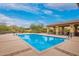 Large community pool area surrounded by desert landscaping and lounge chairs at 9041 E Ivyglen Cir, Mesa, AZ 85207