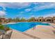 Large community pool with clear blue water, lounge chairs, and a beautiful clubhouse view at 9041 E Ivyglen Cir, Mesa, AZ 85207