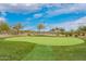 Manicured putting green with desert surroundings, providing a scenic golfing experience at 9041 E Ivyglen Cir, Mesa, AZ 85207