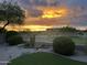 Sunset view of backyard featuring gravel, artificial turf, and views of the surrounding desert landscape at 9286 W Buckhorn Trl, Peoria, AZ 85383