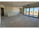 Large open-concept living room area with sliding glass doors to backyard and walls ready for paint at 9614 W Parkway Dr, Tolleson, AZ 85353