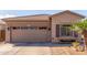 Tan home with a two-car garage, desert landscaping, and a beautiful palm tree near the front window at 9857 E Fairview Ave, Mesa, AZ 85208