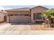 Tan home with a two-car garage, desert landscaping, and a beautiful palm tree near the front window at 9857 E Fairview Ave, Mesa, AZ 85208