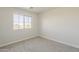 A small bedroom with neutral carpet, a window, and a standard outlet at 9939 W Southgate Ave, Tolleson, AZ 85353