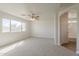 A spacious bedroom boasting a ceiling fan and a door to the bathroom at 9939 W Southgate Ave, Tolleson, AZ 85353