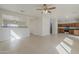 Open-concept living area with fan and view of the kitchen with wood cabinets at 9939 W Southgate Ave, Tolleson, AZ 85353