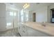 Bright bathroom with double sinks, a large mirror, white cabinets and glass enclosed shower at 10013 E Trent Ave, Mesa, AZ 85212