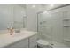 Bathroom featuring white cabinets, vanity, toilet, mirror, and glass-enclosed shower at 10013 E Trent Ave, Mesa, AZ 85212