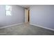 Bright bedroom featuring neutral carpet, light walls, and a doorway leading to other rooms at 10013 E Trent Ave, Mesa, AZ 85212