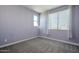 Cozy bedroom with soft carpet, light walls, and natural light from two windows at 10013 E Trent Ave, Mesa, AZ 85212