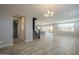 Open-concept living room with wood-look floors and modern light fixture at 10013 E Trent Ave, Mesa, AZ 85212