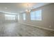 Bright, open living room with wood-look tile flooring and modern chandelier at 10013 E Trent Ave, Mesa, AZ 85212