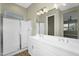 Bathroom featuring dual sinks, large mirror, vanity lighting and frameless glass shower enclosure at 10144 E Thistle Ave, Mesa, AZ 85212