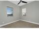 Bedroom with two windows, neutral walls, carpet flooring, and a ceiling fan at 10144 E Thistle Ave, Mesa, AZ 85212