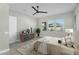 Bright bedroom with a ceiling fan, dresser, large windows, and neutral tones at 10144 E Thistle Ave, Mesa, AZ 85212